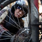 Zhu Xian, 31, fixes a broken wheel in between deliveries from a restaurant on 14th Street.<br/>